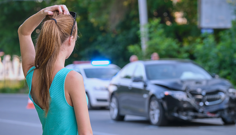 mujer visualizando un accidente de tráfico sin saber cómo actuar antes de un atestado policial